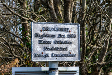 An old and weathered bridleways sign in moorland