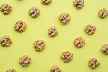 Fototapeta na wymiar Grains of walnut on a yellow background.