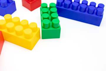 Fototapeta premium Many colorful toy plastic bricks, kit of blocks for building and constructing on white background with copy space