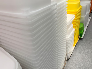 Many stacked colorful plastic containers for storage things objects at home