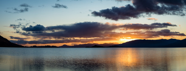 loch linnhe in the argyll region of the highlands of scotland during an autumn sunset showing golden light on the clouds and water and the islands of lismore and shuna
