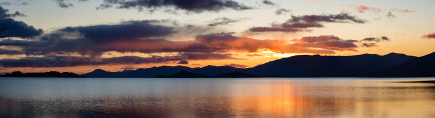 loch linnhe in the argyll region of the highlands of scotland during an autumn sunset showing golden light on the clouds and water and the islands of lismore and shuna