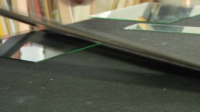 a framer cuts a glass for a frame. Dolly shot