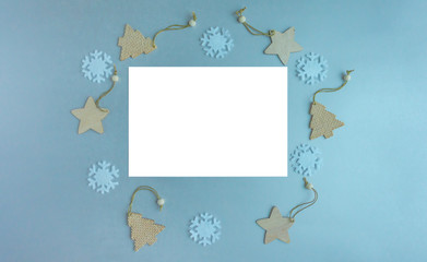 Mocap Christmas and New Year composition. White sheet and christmas decor. Snowflake, wooden christmas tree, stars on a gray-blue background.