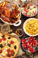 Dinner table with baked chicken, rice with lentils, focaccia and salad