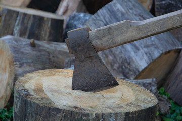 Vintage axe stuck in a wooden stump.