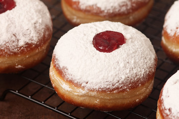 Tasty donuts with jam on wooden background - Hanukkah celebration concept .