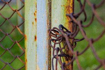 Rusty iron, a part of ragged fence net