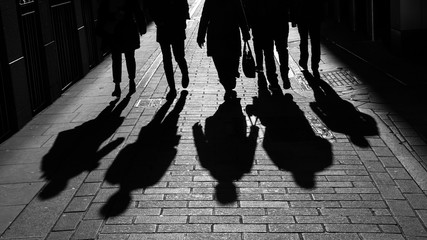 City workers silhouetted walking through alley