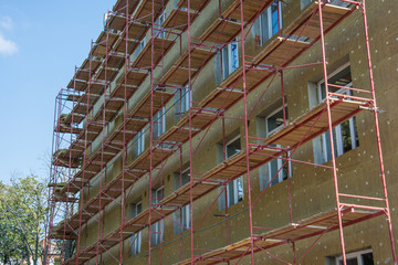 Mineral wool facade insulation of new apartment building with plastic windows and scaffolding