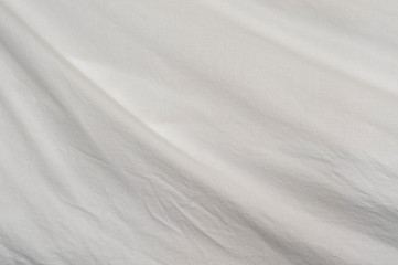 Obraz premium A gentle curve arcs through the frame from upper left to lower right of muslin cloth backdrop with small wrinkles.