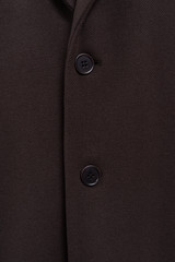 Brown coat texture closeup. Two buttons on woolen clothes. Classic outfit sample.  Buttoned up.