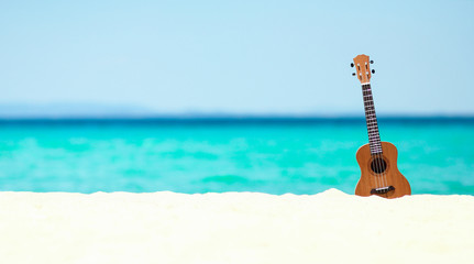 ukulele on the sand by the sea in summer - obrazy, fototapety, plakaty