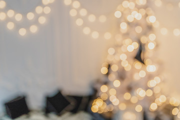 Gold defocused christmas garland and fir with baubles and ribbons on white.