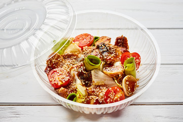 Tasty salad with smoked eel, avocado and tomato. Healthy food concept