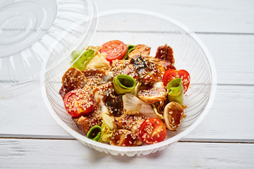 Tasty salad with smoked eel, avocado and tomato. Healthy food concept