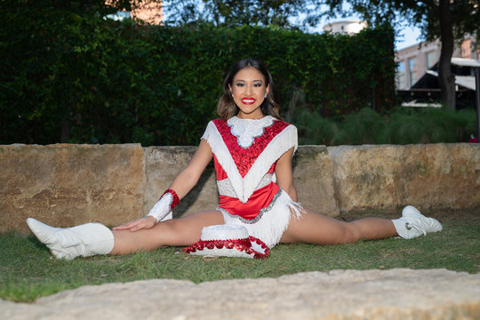 Young and beautiful Hispanic high school girl in her school dance uniform posing for school pictures