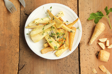 Pastinaken gebraten mit frischen Kräutern Teller Brett