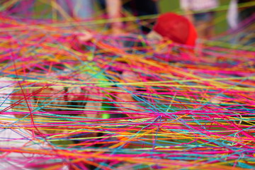 Close-up of multicolored tangled wool threads and yarn balls. People throw each other yarn balls...