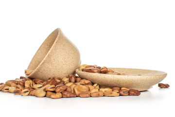 Lot of whole fresh brown bean vicia faba with ceramic cup, saucer isolated on white background