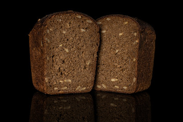 Group of two halves of fresh baked dark bread isolated on black glass
