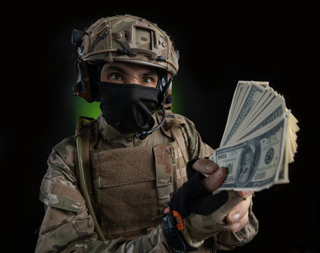 a male soldier in military clothes with a weapon on a dark background