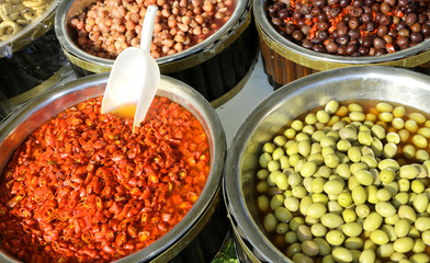 Mediterranean market stall with big olives and red peppers for s