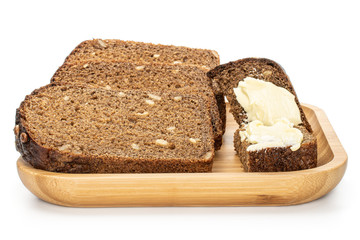 Group of three slices of fresh baked dark bread on wooden square plate isolated on white background