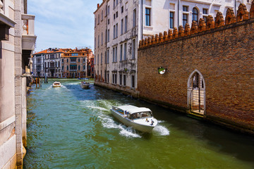 Grand Canal in Venice with boats and gandoles dockt motor boat near the bridge.