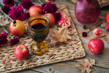 Fototapeta na wymiar Glass of red wine, apples, grapefruits, autumn leaves and flowers