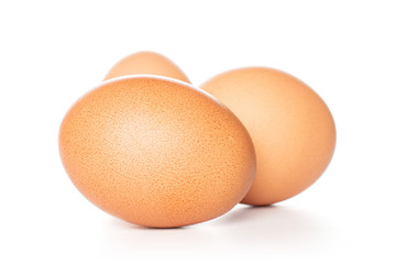 Group of three whole chicken eggs isolated on white background