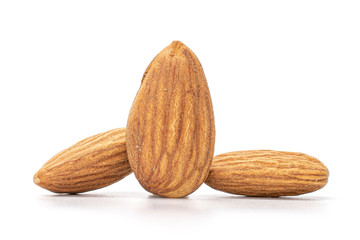 Group of three whole peeled almond nuts isolated on white background