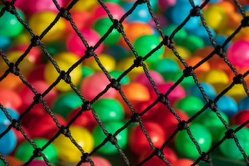 Fototapeta premium The net rope and colorful ball in children's playroom. Tight knot is used for safety barrier net. Children's playground