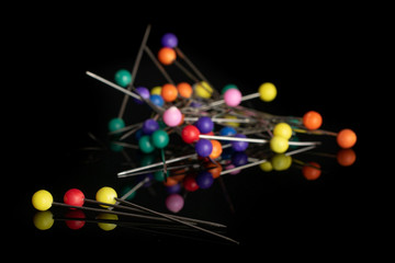 Lot of whole haberdashery item needles heap isolated on black glass