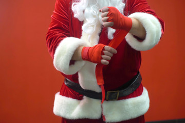 Santa Claus Fighter kickbox With Red Bandages against the background of a red wall