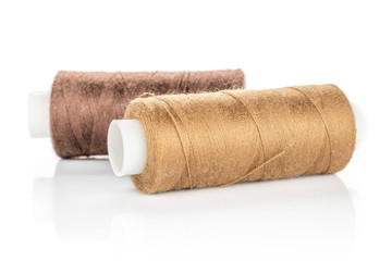 Group of two whole haberdashery item brown thread spools isolated on white background