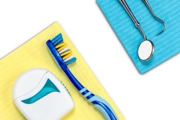 Dentist desk with toothbrush, floss, dental explorer probe and dentist mirror on white background...
