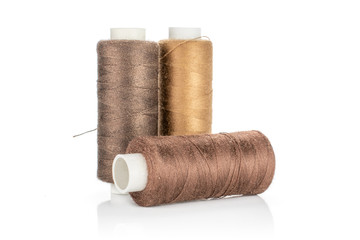 Group of three whole haberdashery item brown spools isolated on white background