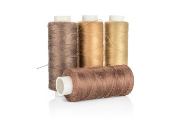 Group of four whole haberdashery item brown spools isolated on white background
