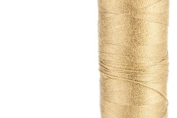 One whole haberdashery item beige thread spool macro isolated on white background