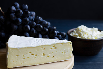 cheese, grapes, on a wooden board