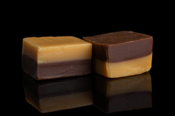 Group of two whole sweet brown caramel chocolate candy isolated on black glass