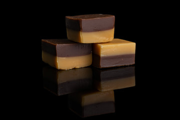 Group of three whole sweet brown caramel chocolate candy isolated on black glass
