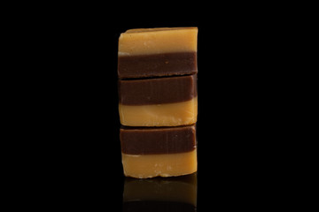 Group of three whole sweet brown caramel chocolate candy isolated on black glass