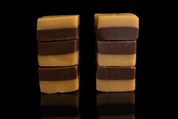 Group of six whole sweet brown caramel chocolate candy in two columns isolated on black glass