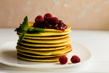 pancakes with raspberries on a white plate