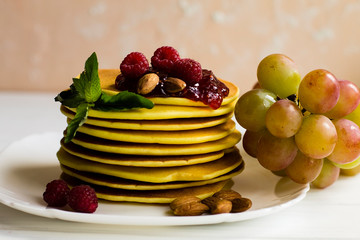 pancakes with raspberries on a white plate