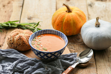 Vegetarian autumn pumpkin cream soup with seeds. Seasonal autumn food - pumpkin soup with thyme. Pumpkin soup with herbs, cream, breadcrumbs and parmesan, served in a bowl, top view. Place for text