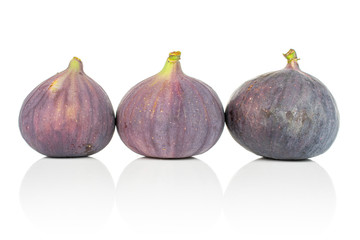Group of three whole fresh purple fig in row isolated on white background