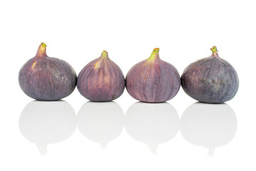 Group of four whole fresh purple fig isolated on white background